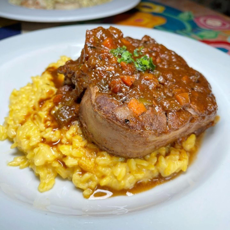 Braised short rib with rich brown sauce and vegetables, served over creamy yellow risotto at Cafe Gia.